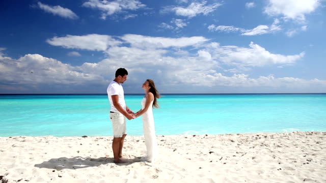 Joven-hermosa-de-recién-casados-hacer-promesas-de-fidelidad-respecto-en-la-playa