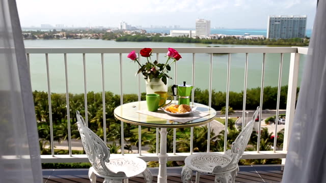Delicious-breakfast--with-coffee-fresh-croissants-and-slice-of-orange-fruit-on-balcony
