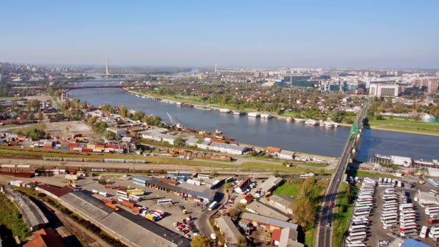 Aerial-360-degrees-pan-of-a-city-with-train-station,-bus-station,-river,-bridges