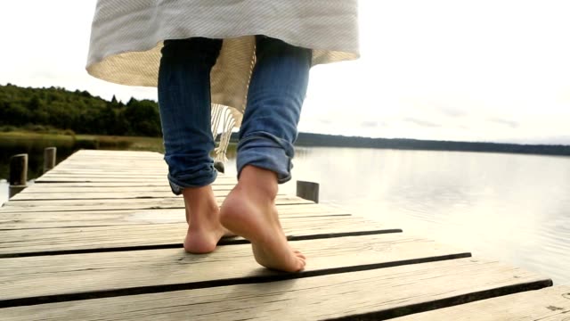 Nahaufnahme-der-weiblichen-Füße-stehen-auf-Steg-über-dem-See