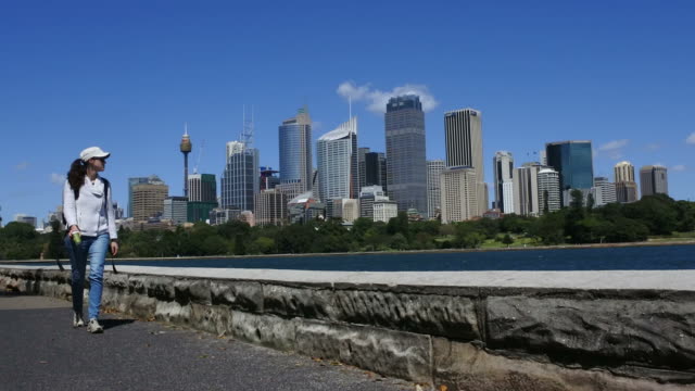 Frau-Spaziergänge-entlang-der-Skyline-von-Sydney