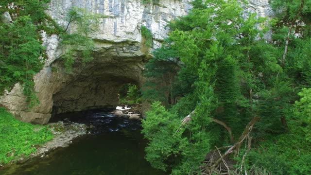 River-Running-Through-Cave-At-Summer