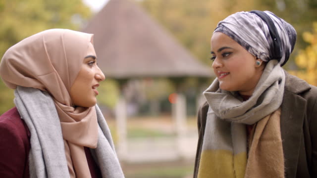 Encuentro-de-dos-mujeres-musulmanas-británicas-en-parque-urbano