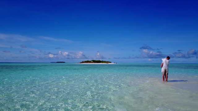 v03944-fliegenden-Drohne-Luftaufnahme-der-Malediven-weißen-Sandstrand-2-Personen-junges-Paar-Mann-Frau-romantische-Liebe-auf-sonnigen-tropischen-Inselparadies-mit-Aqua-blau-Himmel-Meer-Wasser-Ozean-4k