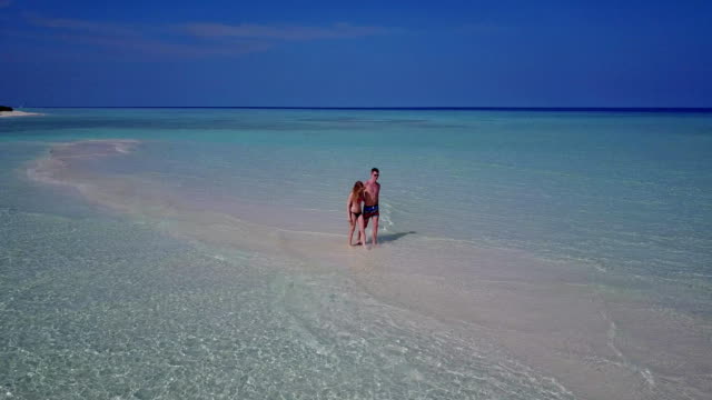 v03867-fliegenden-Drohne-Luftaufnahme-der-Malediven-weißen-Sandstrand-2-Personen-junges-Paar-Mann-Frau-romantische-Liebe-auf-sonnigen-tropischen-Inselparadies-mit-Aqua-blau-Himmel-Meer-Wasser-Ozean-4k
