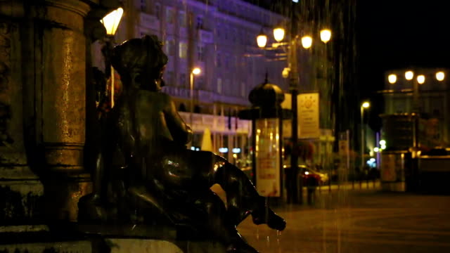 Statue-von-Mädchen-sitzt-auf-dem-Rand-des-Brunnens-in-der-Nacht,-Romantik-Architektur