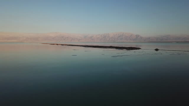Low-level-drone-flight-over-the-water-of-the-Dead-Sea,-Israel-at-sunset
