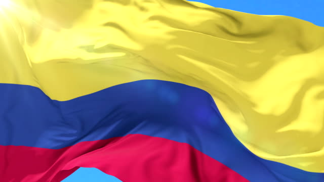 Bandera-colombiana-ondeando-en-el-viento-en-lento-con-cielo-azul,-lazo