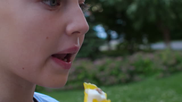 Chica-adolescente-de-retrato-comiendo-helado-amarillo-extremo-de-cerca