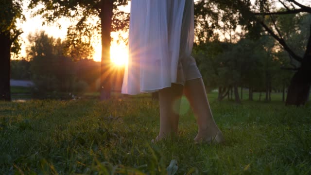 Sun-shine-through-transparent-white-flying-skirt,-woman-legs-close-up