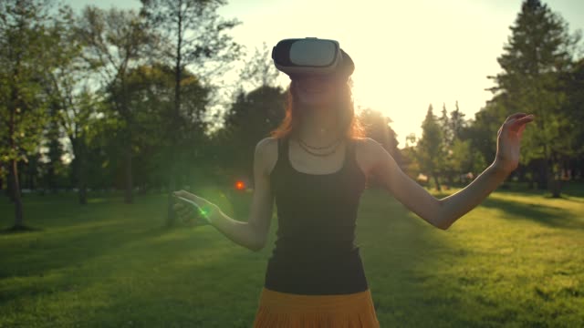 Beautiful-caucasian-woman-enjoy-virtual-reality-walking-on-grass-in-park