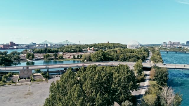 aerial-drone-footage-of-montreal-with-bridges-and-a-park-area-plus-ile-sainte-helene-island-with-the-biosphere-dome-in-the-background
