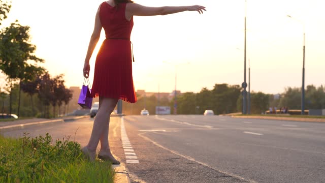 Woman-in-red-dress-hitchhike-on-road,-make-long-arm,-car-drive