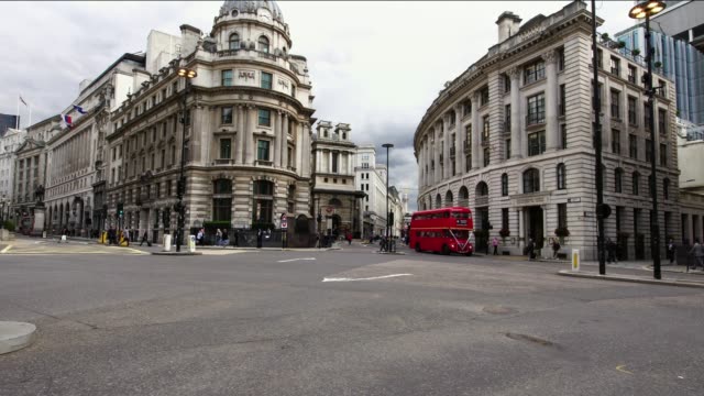 Iconic-red-double-decker-bus-passing-during-morning-rush-hour-in-the-business-district-London,-UK.