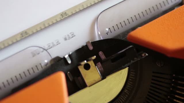 Close-up-footage-of-an-old-typewriter-and-a-person-writing-NUCLEAR-WAR-on-it...