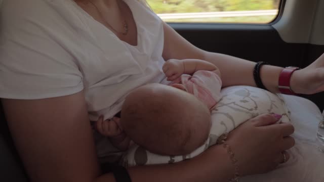 Mutter-stillen-Baby-und-Trinkwasser-im-Auto