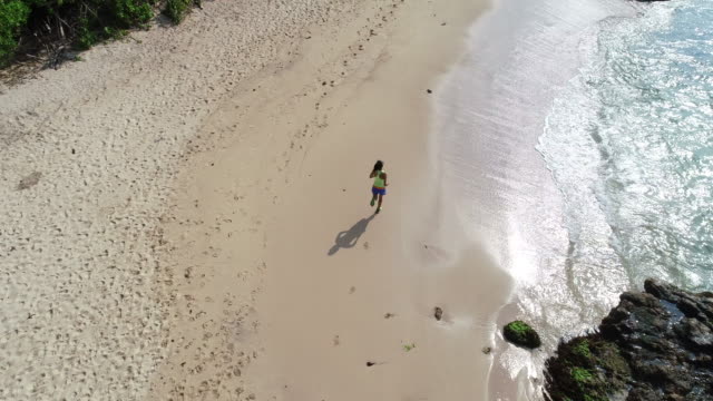 Gesunde-Lebensweise-junge-Frau-mit-offenen-Armen-zum-Meer-am-Strand,-Luftaufnahmen