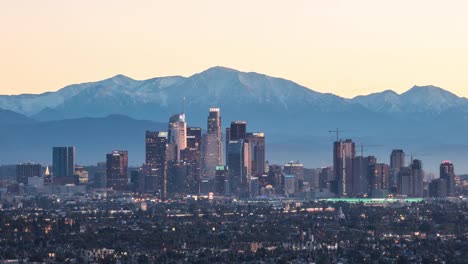 Downtown-Los-Angeles-Skyline-With-Snowy-Mountains-Sunrise-Timelapse-Close