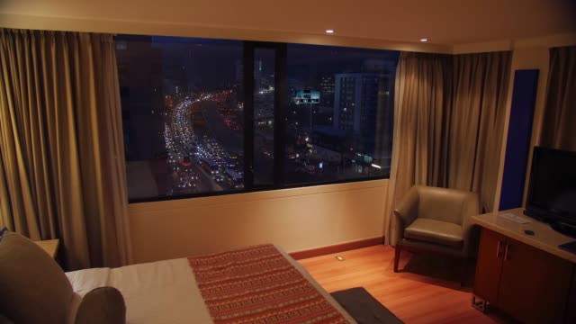 Room-with-night-view-and-time-lapse-of-busy-street-outside---Bogota,-Colombia