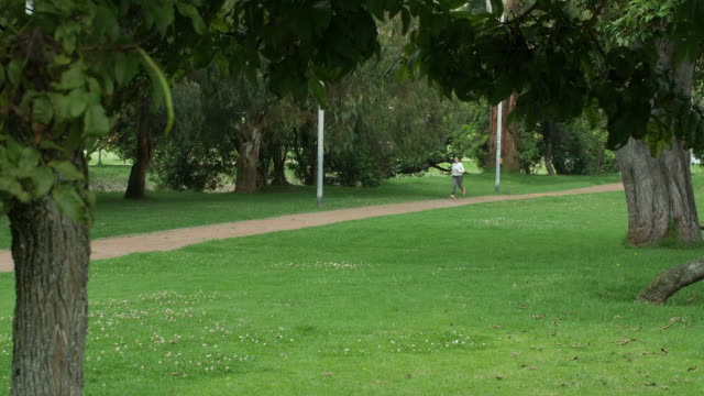 Woman-jogging-in-lush-city-park-in-Bogotá,-Colombia
