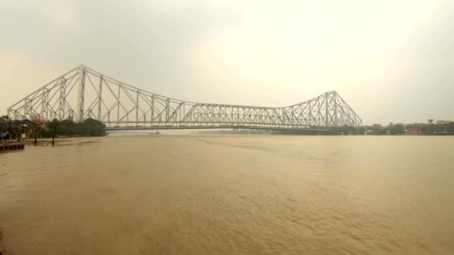 Howrah-Brücke-unter-dem-Fluss-Hoogli-Fähranlegestelle-mit-Menschen-bewölkt-Tag-Kolkata