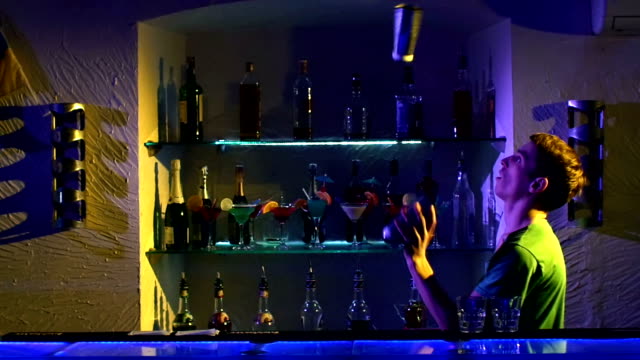 Professional-bartender-making-cool,-amazing-tricks-three-shakers,-juggling-standing-behind-the-bar,-catching,-throwing-up,-slow-motion