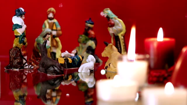 Weihnachten-Weihnachtskrippe-mit-Kerzen-auf-Rot