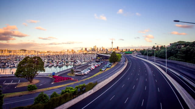 Zeitraffer-Autobahn-Verkehr-mit-Urban-Skyline-von-Auckland,-Neuseeland