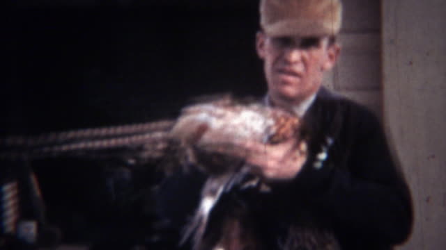 1939:-hombre-caza-usa-collar-de-aves-faisanes-muertos.