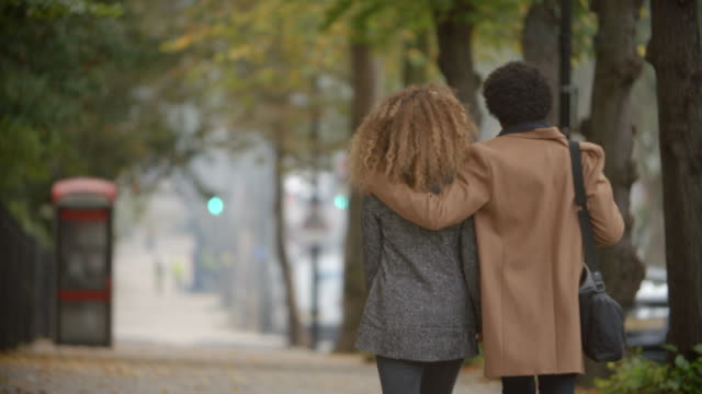 Vista-posterior-de-la-romántica-pareja-caminando-en-la-calle-de-otoño-en-la-ciudad-de