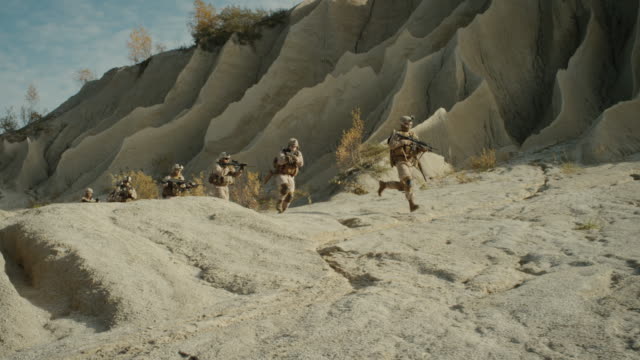 Squad-of-Fully-Equipped,-Armed-Soldiers-Running-in-the-Desert.