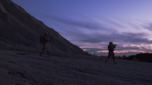 Gruppe-von-bewaffneten-Soldaten-während-der-Nachtbetrieb-in-Wüste-Umgebung-laufen.-Slow-Motion.