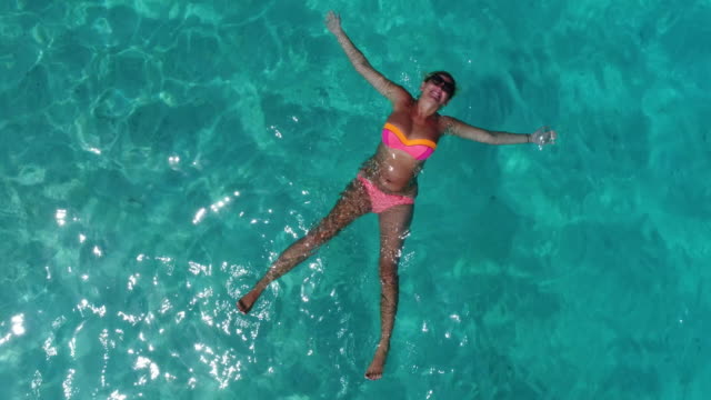 Schönes-Mädchen-legt-im-klaren-blauen-Wasser-der-Malediven-Lagune