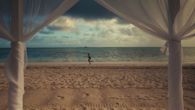Tropische-Insel-Strand-Sonnenaufgang-und-laufende-Mann-am-Strand-in-Punta-Cana