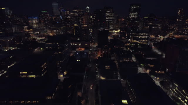 Pan-hasta-revelar-rascacielos-edificios-en-la-ciudad-en-helicóptero-durante-la-noche