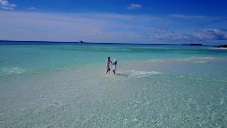 v03912-fliegenden-Drohne-Luftaufnahme-der-Malediven-weißen-Sandstrand-2-Personen-junges-Paar-Mann-Frau-romantische-Liebe-auf-sonnigen-tropischen-Inselparadies-mit-Aqua-blau-Himmel-Meer-Wasser-Ozean-4k