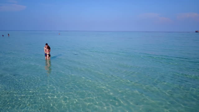 v03989-fliegenden-Drohne-Luftaufnahme-der-Malediven-weißen-Sandstrand-2-Personen-junges-Paar-Mann-Frau-romantische-Liebe-auf-sonnigen-tropischen-Inselparadies-mit-Aqua-blau-Himmel-Meer-Wasser-Ozean-4k