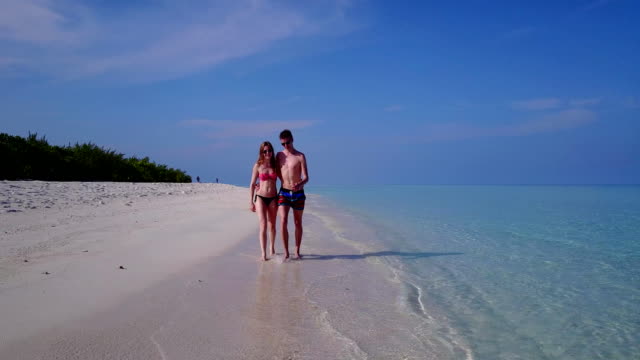 v03872-fliegenden-Drohne-Luftaufnahme-der-Malediven-weißen-Sandstrand-2-Personen-junges-Paar-Mann-Frau-romantische-Liebe-auf-sonnigen-tropischen-Inselparadies-mit-Aqua-blau-Himmel-Meer-Wasser-Ozean-4k