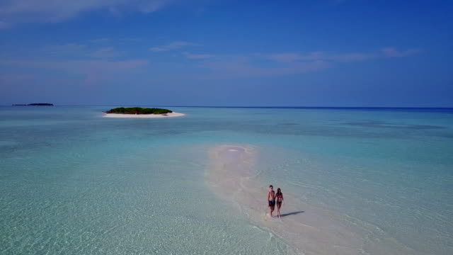 v03892-fliegenden-Drohne-Luftaufnahme-der-Malediven-weißen-Sandstrand-2-Personen-junges-Paar-Mann-Frau-romantische-Liebe-auf-sonnigen-tropischen-Inselparadies-mit-Aqua-blau-Himmel-Meer-Wasser-Ozean-4k