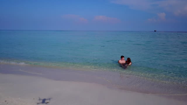 v03974-fliegenden-Drohne-Luftaufnahme-der-Malediven-weißen-Sandstrand-2-Personen-junges-Paar-Mann-Frau-romantische-Liebe-auf-sonnigen-tropischen-Inselparadies-mit-Aqua-blau-Himmel-Meer-Wasser-Ozean-4k