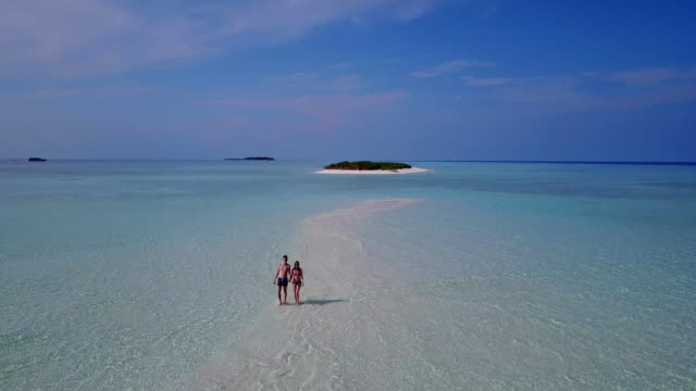 v03886-fliegenden-Drohne-Luftaufnahme-der-Malediven-weißen-Sandstrand-2-Personen-junges-Paar-Mann-Frau-romantische-Liebe-auf-sonnigen-tropischen-Inselparadies-mit-Aqua-blau-Himmel-Meer-Wasser-Ozean-4k