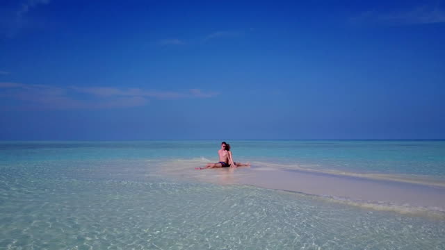 v03985-fliegenden-Drohne-Luftaufnahme-der-Malediven-weißen-Sandstrand-2-Personen-junges-Paar-Mann-Frau-romantische-Liebe-auf-sonnigen-tropischen-Inselparadies-mit-Aqua-blau-Himmel-Meer-Wasser-Ozean-4k
