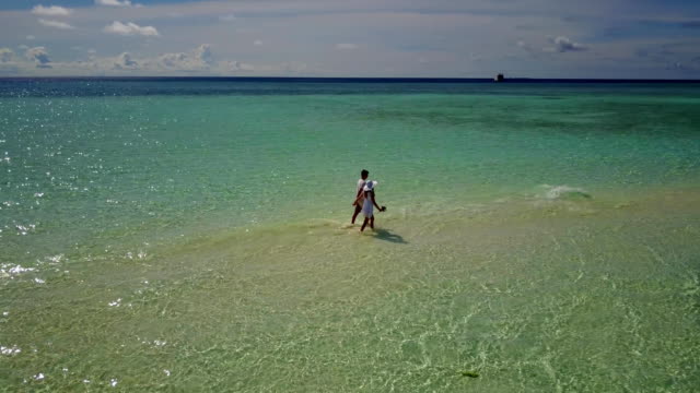 v03905-fliegenden-Drohne-Luftaufnahme-der-Malediven-weißen-Sandstrand-2-Personen-junges-Paar-Mann-Frau-romantische-Liebe-auf-sonnigen-tropischen-Inselparadies-mit-Aqua-blau-Himmel-Meer-Wasser-Ozean-4k