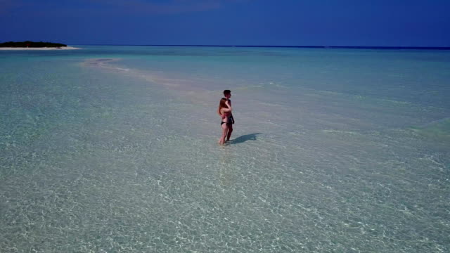 v03896-fliegenden-Drohne-Luftaufnahme-der-Malediven-weißen-Sandstrand-2-Personen-junges-Paar-Mann-Frau-romantische-Liebe-auf-sonnigen-tropischen-Inselparadies-mit-Aqua-blau-Himmel-Meer-Wasser-Ozean-4k
