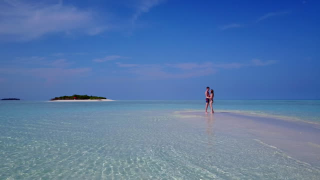 v03883-fliegenden-Drohne-Luftaufnahme-der-Malediven-weißen-Sandstrand-2-Personen-junges-Paar-Mann-Frau-romantische-Liebe-auf-sonnigen-tropischen-Inselparadies-mit-Aqua-blau-Himmel-Meer-Wasser-Ozean-4k