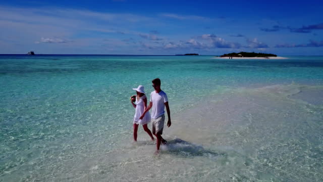 v03921-fliegenden-Drohne-Luftaufnahme-der-Malediven-weißen-Sandstrand-2-Personen-junges-Paar-Mann-Frau-romantische-Liebe-auf-sonnigen-tropischen-Inselparadies-mit-Aqua-blau-Himmel-Meer-Wasser-Ozean-4k