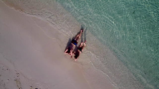 v03997-fliegenden-Drohne-Luftaufnahme-der-Malediven-weißen-Sandstrand-2-Personen-junges-Paar-Mann-Frau-romantische-Liebe-auf-sonnigen-tropischen-Inselparadies-mit-Aqua-blau-Himmel-Meer-Wasser-Ozean-4k