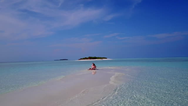 v03877-fliegenden-Drohne-Luftaufnahme-der-Malediven-weißen-Sandstrand-2-Personen-junges-Paar-Mann-Frau-romantische-Liebe-auf-sonnigen-tropischen-Inselparadies-mit-Aqua-blau-Himmel-Meer-Wasser-Ozean-4k