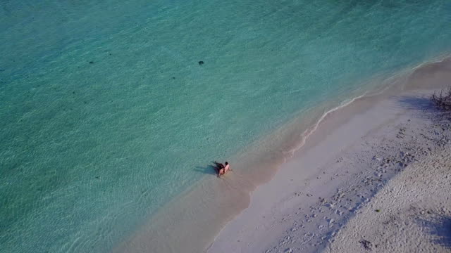 v03951-fliegenden-Drohne-Luftaufnahme-der-Malediven-weißen-Sandstrand-2-Personen-junges-Paar-Mann-Frau-romantische-Liebe-auf-sonnigen-tropischen-Inselparadies-mit-Aqua-blau-Himmel-Meer-Wasser-Ozean-4k