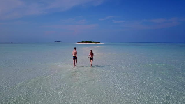 v03964-fliegenden-Drohne-Luftaufnahme-der-Malediven-weißen-Sandstrand-2-Personen-junges-Paar-Mann-Frau-romantische-Liebe-auf-sonnigen-tropischen-Inselparadies-mit-Aqua-blau-Himmel-Meer-Wasser-Ozean-4k